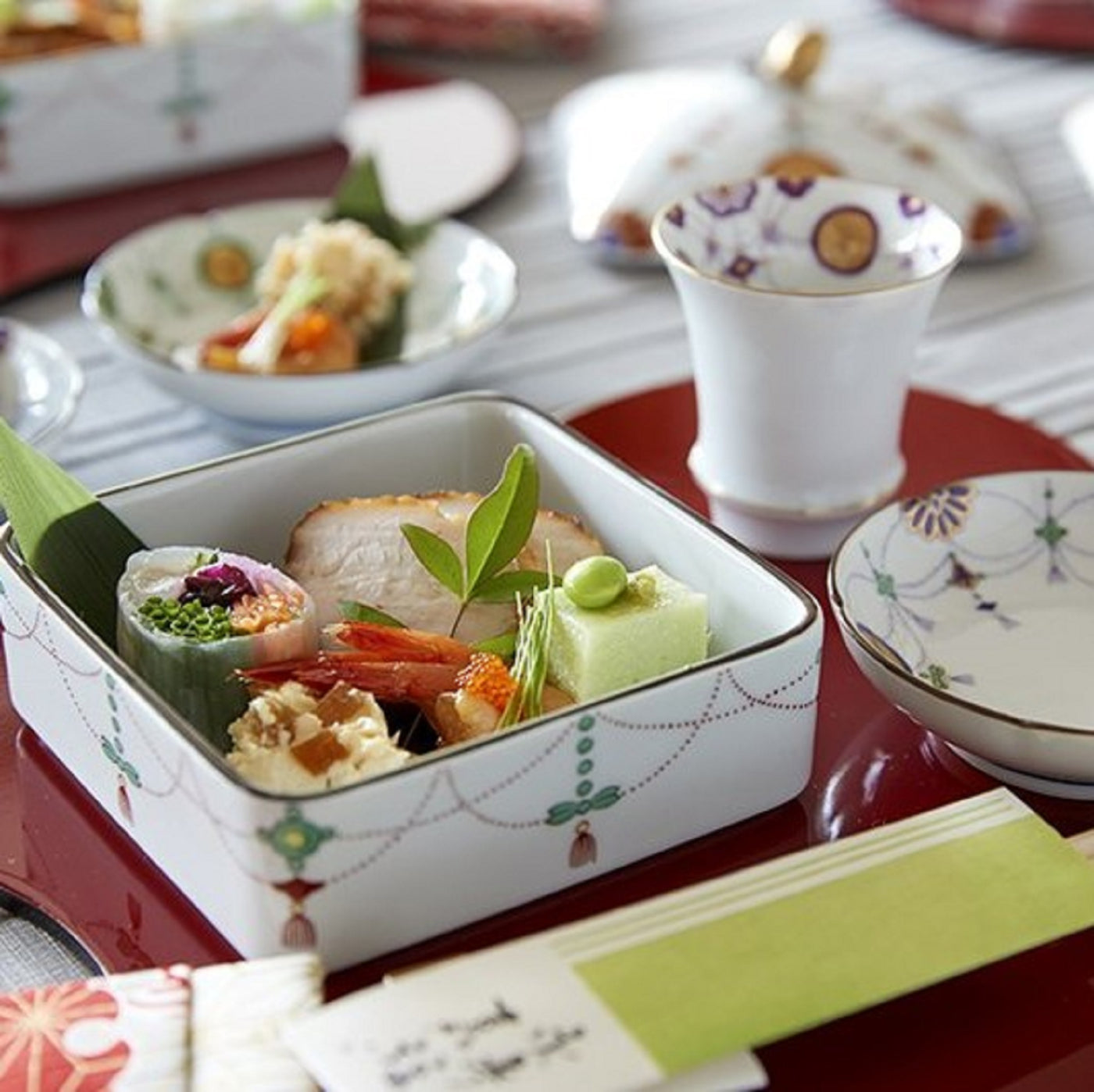 Rectangular two-tiered food box: Yoraku pattern with lavish red-rimmed sun disks